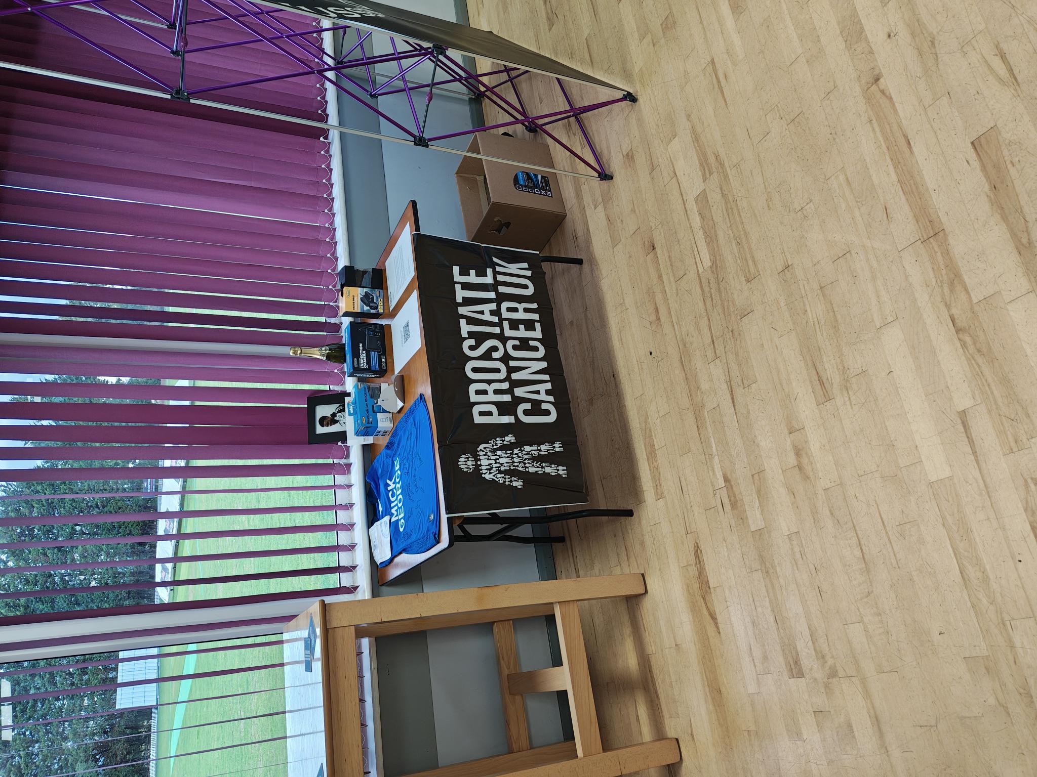 Raffle table with prizes in support of Prostate Cancer UK.