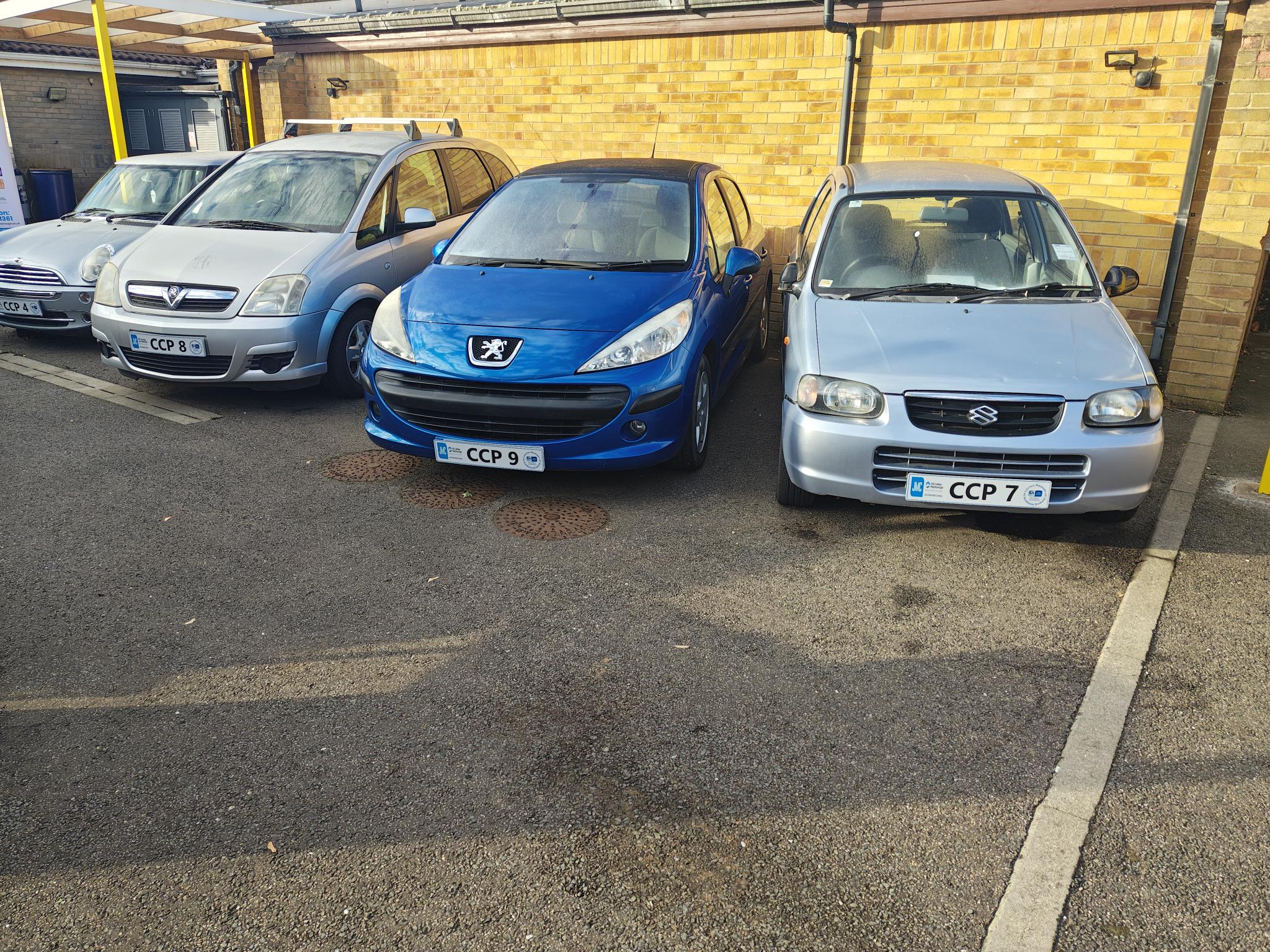 Row of college project cars parked outside with display plates.